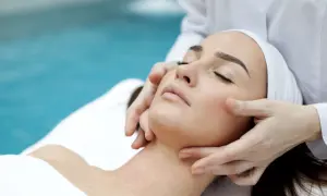 Manos expertas realizan un suave drenaje linfático facial, promoviendo la relajación y el bienestar.