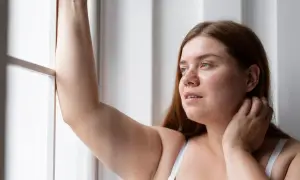 Mujer con brazo levantado, reflexionando sobre la radiofrecuencia en brazos para mejorar la textura de la piel.