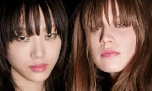 Dos modelos con flequillo hacia adelante y maquillaje llamativo en los ojos.