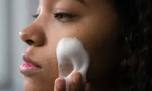 Una mujer se aplica espuma para una limpieza facial profunda. Su piel luce radiante y fresca.