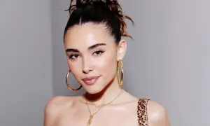 Mujer con un peinado recogido y grandes aretes dorados, luciendo un **clean look** que resalta su belleza natural.