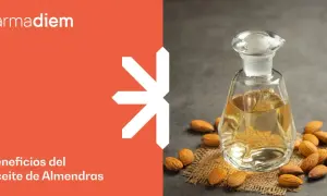 Frasco de aceite de almendras y almendras enteras. Descubre para qué sirve el aceite de almendras y sus beneficios.