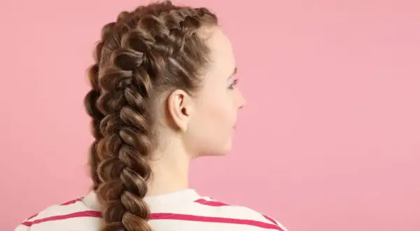 Una joven con dos trenzas gruesas y elaboradas, mostrando diferentes tipos de trenza.