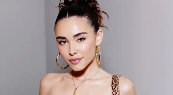Mujer con un peinado recogido y grandes aretes dorados, luciendo un **clean look** que resalta su belleza natural.