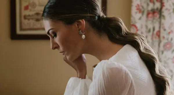 Novia con coleta con ondas para su boda, luciendo un elegante pendiente de perla.