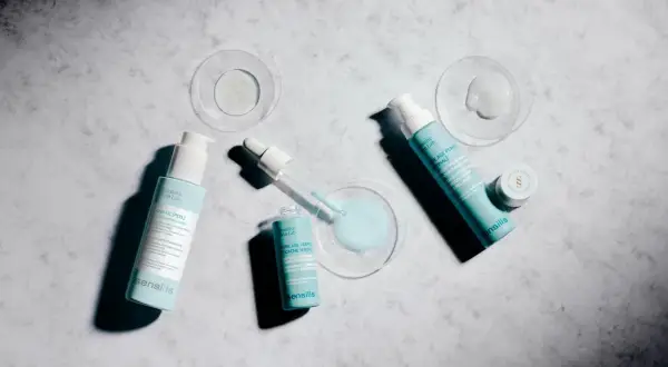 Varias botellas y un gotero de productos Sensilis sobre fondo de mármol. Opiniones sobre serum Sensilis: Pure Age Perfect [Retinal] y Azelaic [Peel].