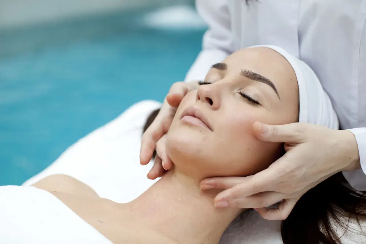 Manos expertas realizan un suave drenaje linfático facial, promoviendo la relajación y el bienestar.