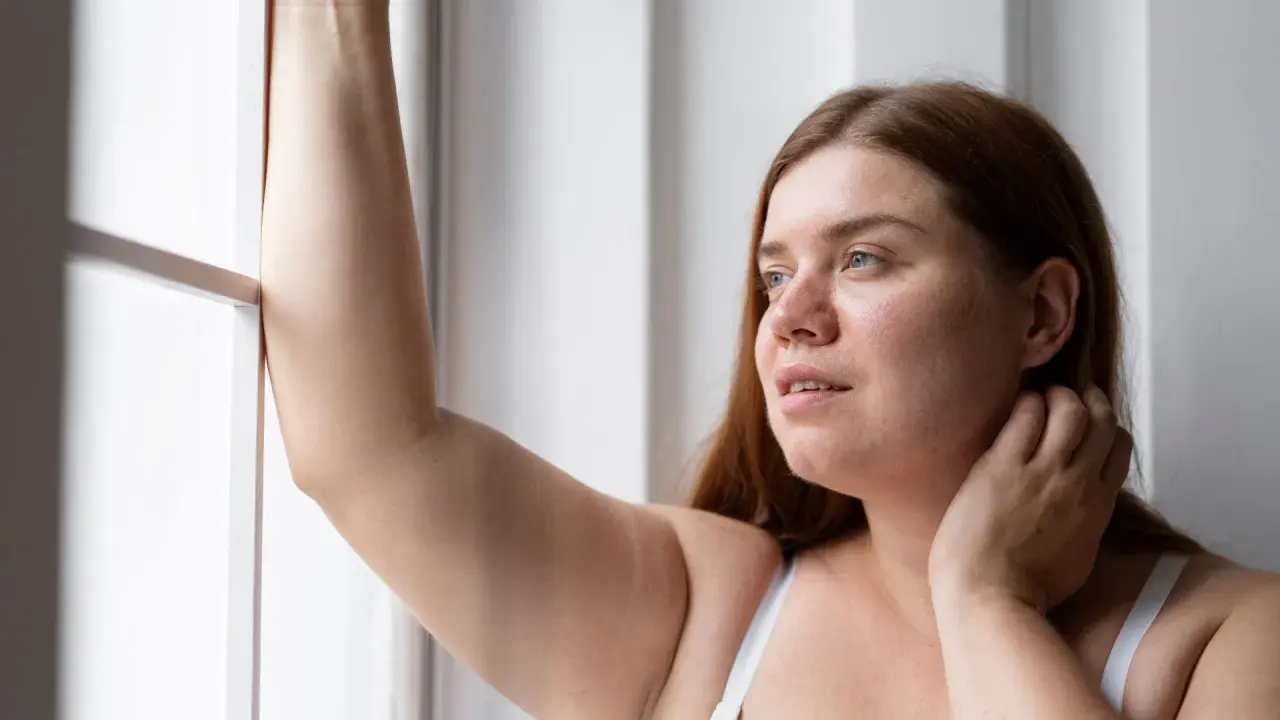 Mujer con brazo levantado, reflexionando sobre la radiofrecuencia en brazos para mejorar la textura de la piel.