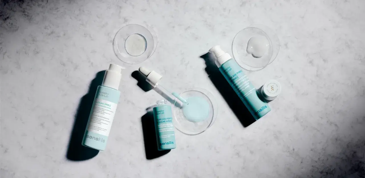Varias botellas y un gotero de productos Sensilis sobre fondo de mármol. Opiniones sobre serum Sensilis: Pure Age Perfect [Retinal] y Azelaic [Peel].