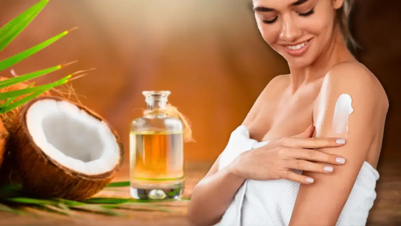 Una mujer sonríe mientras se aplica crema en el brazo, disfrutando de los beneficios del aceite de coco en la piel. Coco y aceite en primer plano.