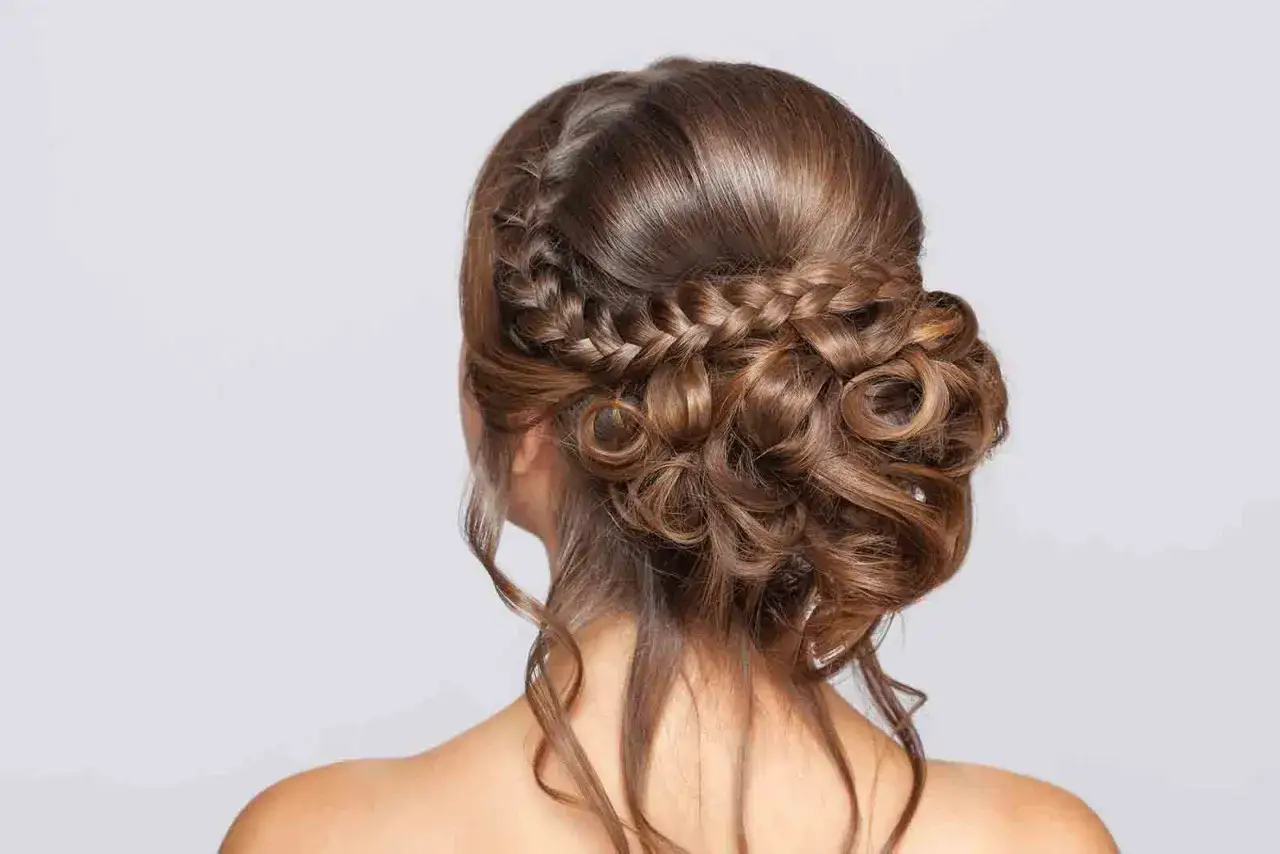 Peinados para ir a trabajar media melena: un recogido bajo con trenzas y rizos, elegante y práctico.