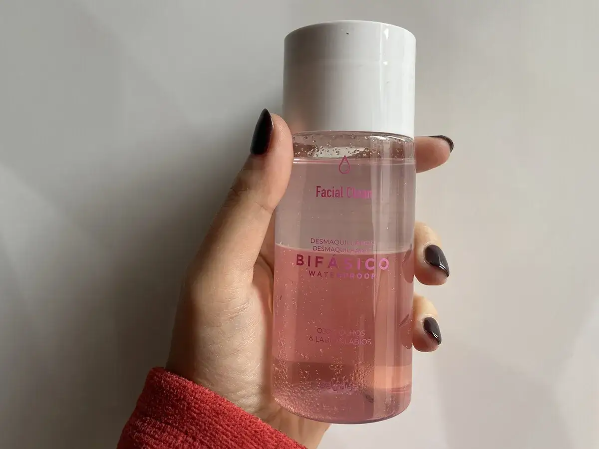 Mano sujetando un agua micelar rosa Bif&aacute;sico de Mercadona, ideal para desmaquillar ojos y labios.